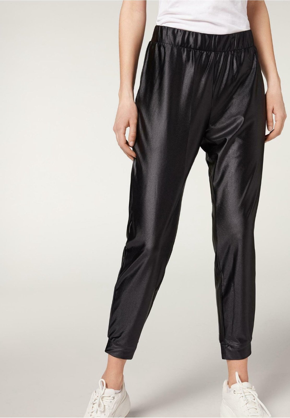 Un legging noir en imitation cuir avec une taille élastiquée.