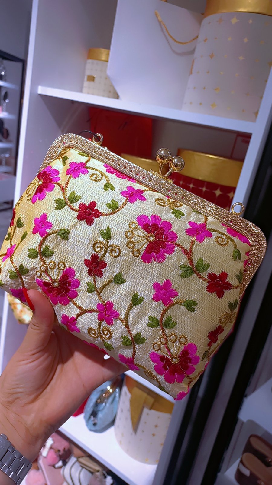 Pochette de soirée crème présente une broderie florale multicolore vibrante et un fermoir métallique doré