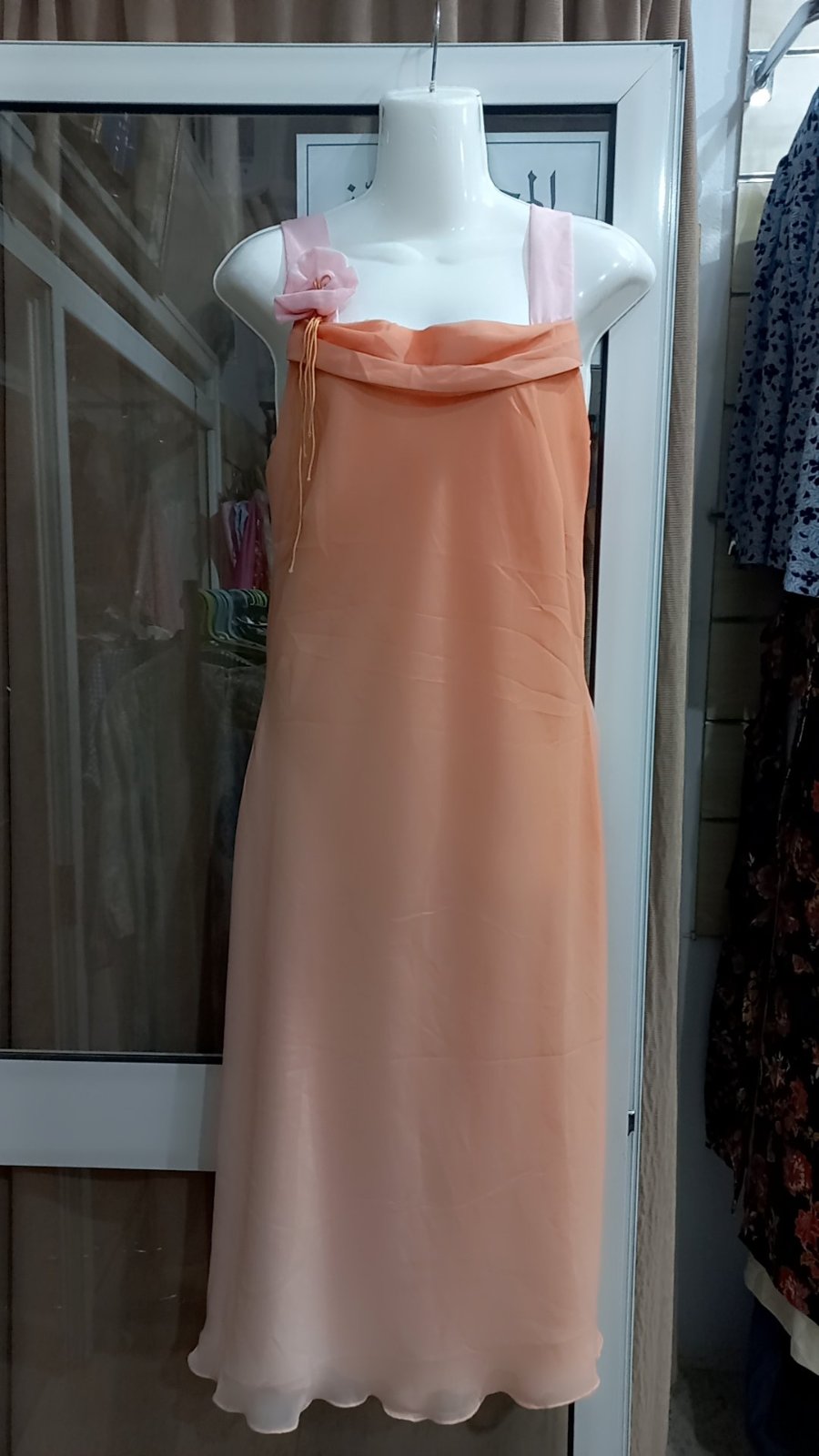 Robe de cérémonie présente un corsage drapé en mousseline corail st doublure satin rose  cet des bretelles rose pastel accentuées d'une fleur en tissu