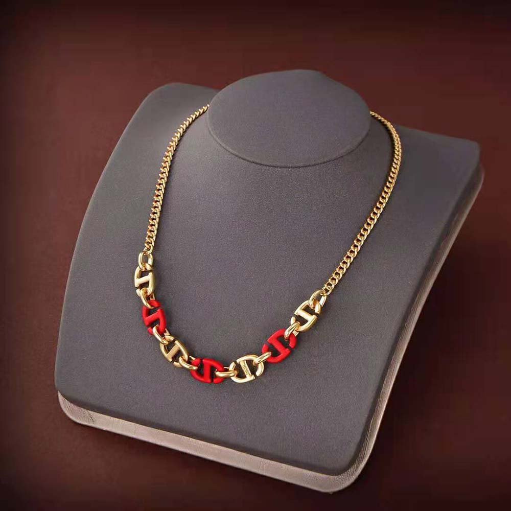 Collier en acier inoxydable ressemble au modèle Christian Dior CD Navy avec ses maillons dorés et ses accents en laque rouge