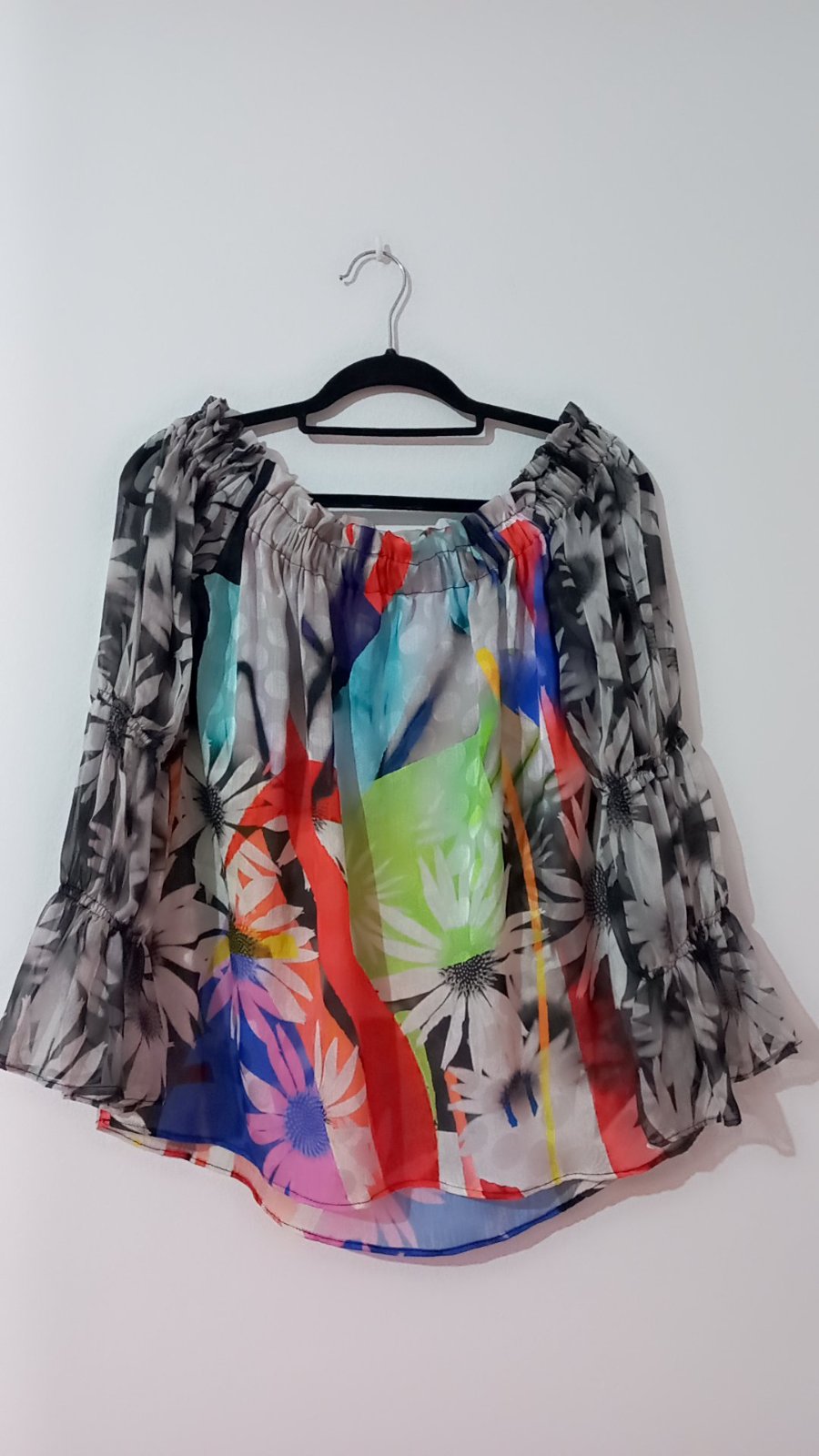 Blouse de la marque Derhy, modèle Lamia, se distingue par son motif floral coloré et ses manches longues transparentes.