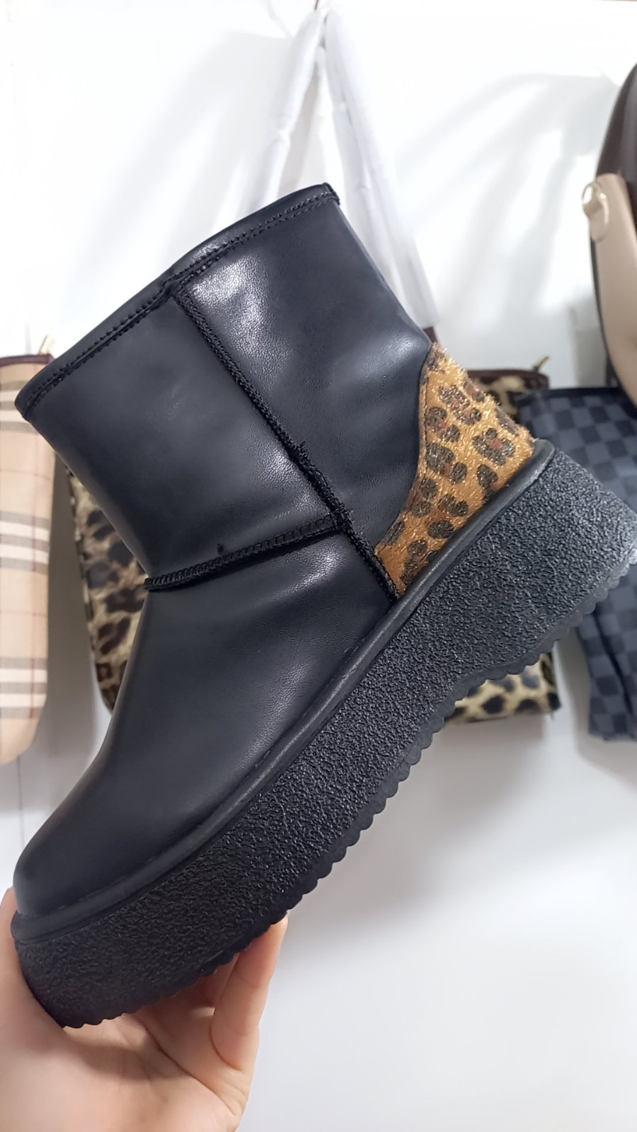 Une bottine en cuir noir avec un motif léopard. 