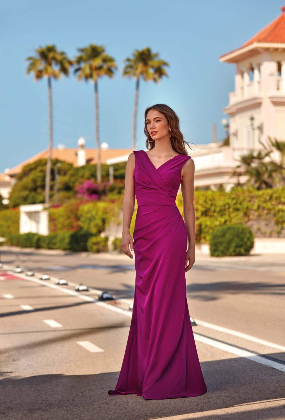 Robe longue en couleur magenta avec un décolleté en V et des détails plissés sur la taille est un modèle de soirée élégant