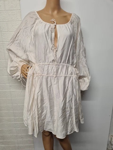 Robe H&M de couleur crème présente une coupe oversize confortable avec des détails à nouer sur le devant