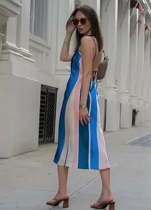 Robe midi satinée à bretelles Lemlem x H&M présente des rayures verticales bleues, roses et blanches.