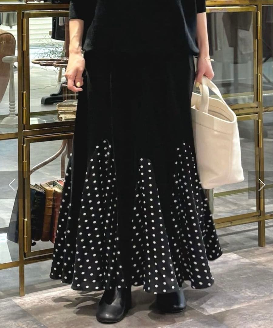 Longue jupe noire, probablement de la marque Tally Weijl, se distingue par des panneaux inférieurs décorés de petits motifs blancs.   