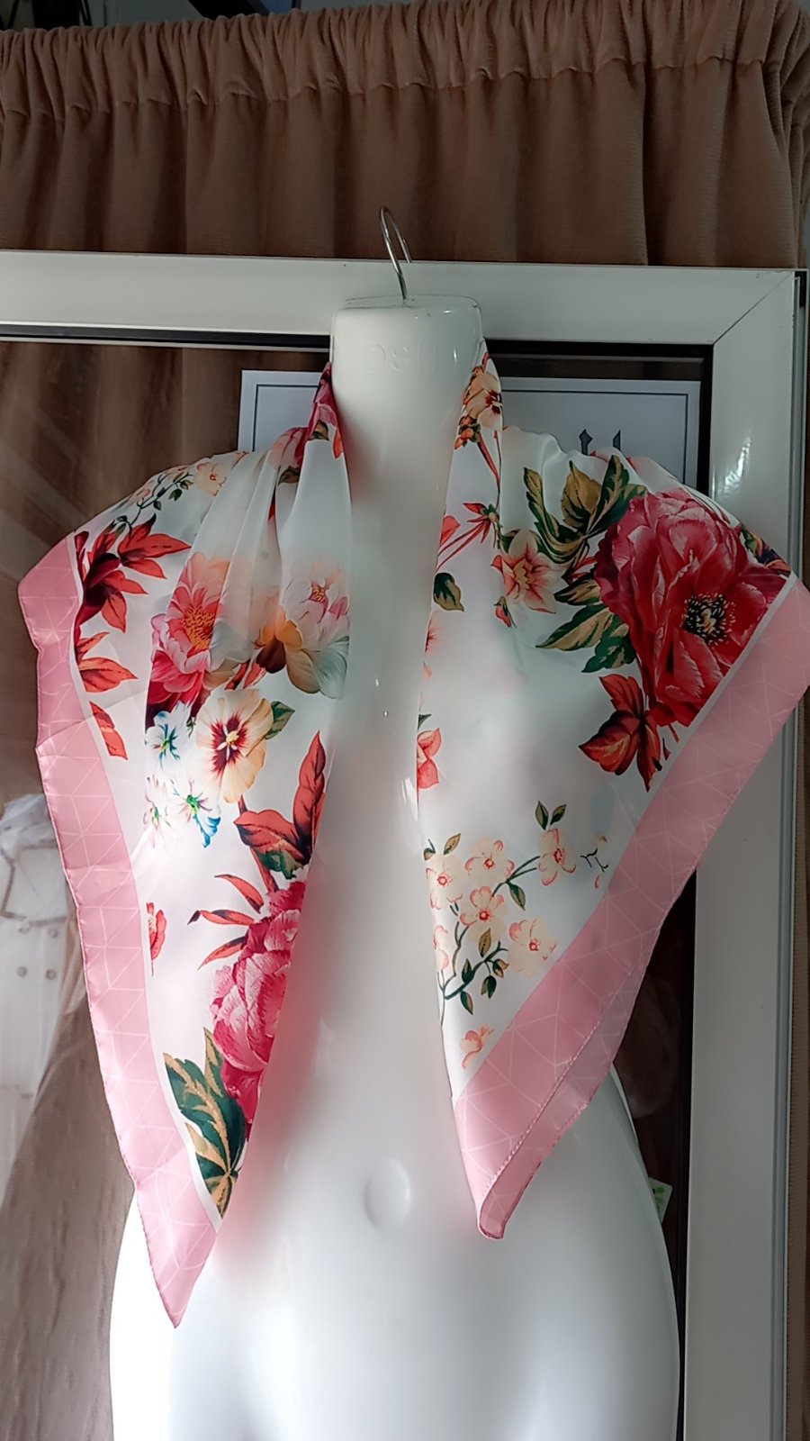 Un foulard carré pour femme en satin de la marque just cavalli , orné d'un motif floral et bordé d'une bande rose. 
