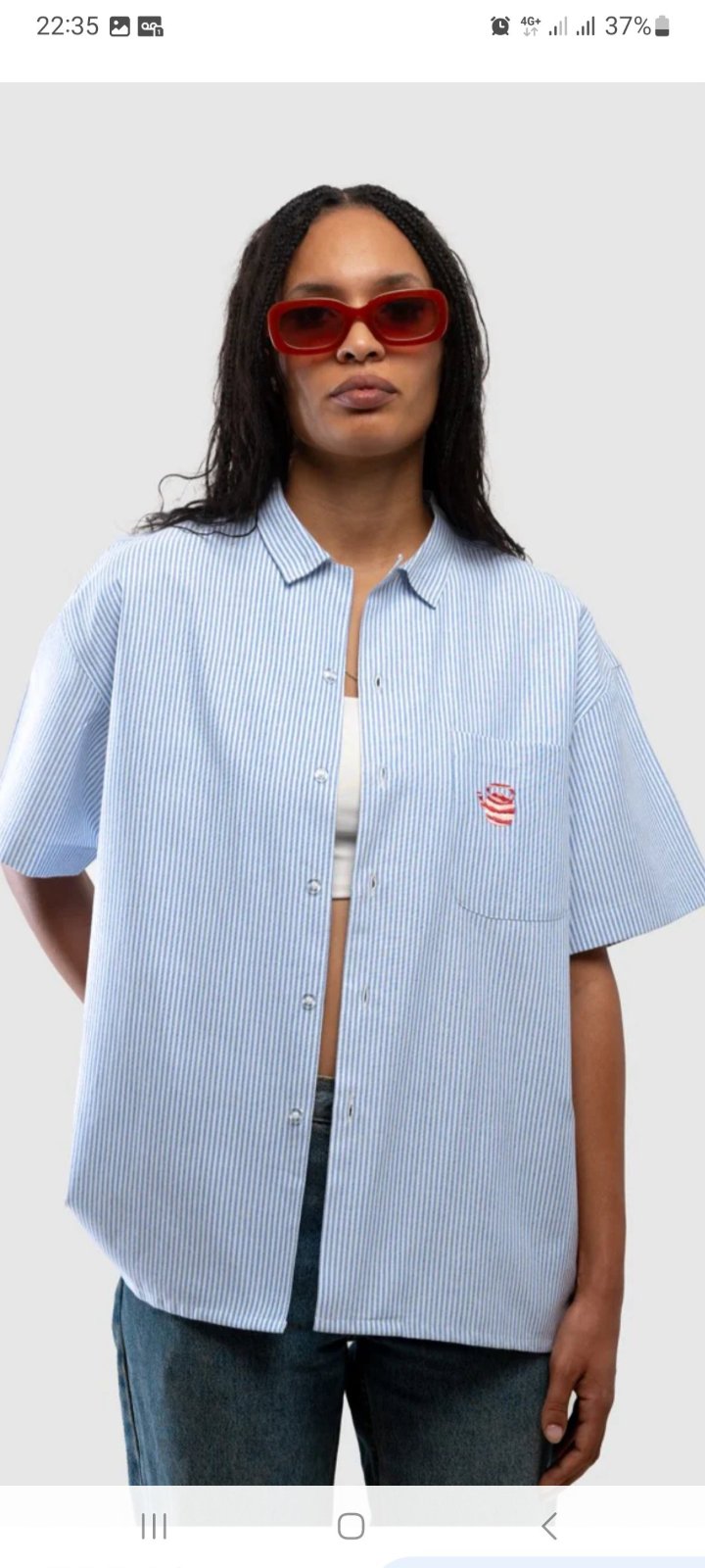  chemise bleu ciel à rayures verticales est ornée de broderies distinctives et de détails floraux sur la patte de boutonnage
