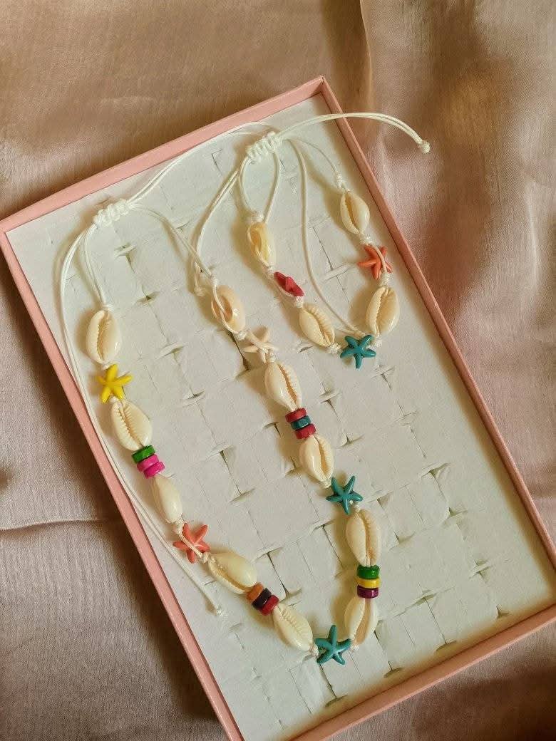 Collier de style bohème est fabriqué avec des coquillages cauris blancs et des perles colorées en forme d'étoiles de mer.