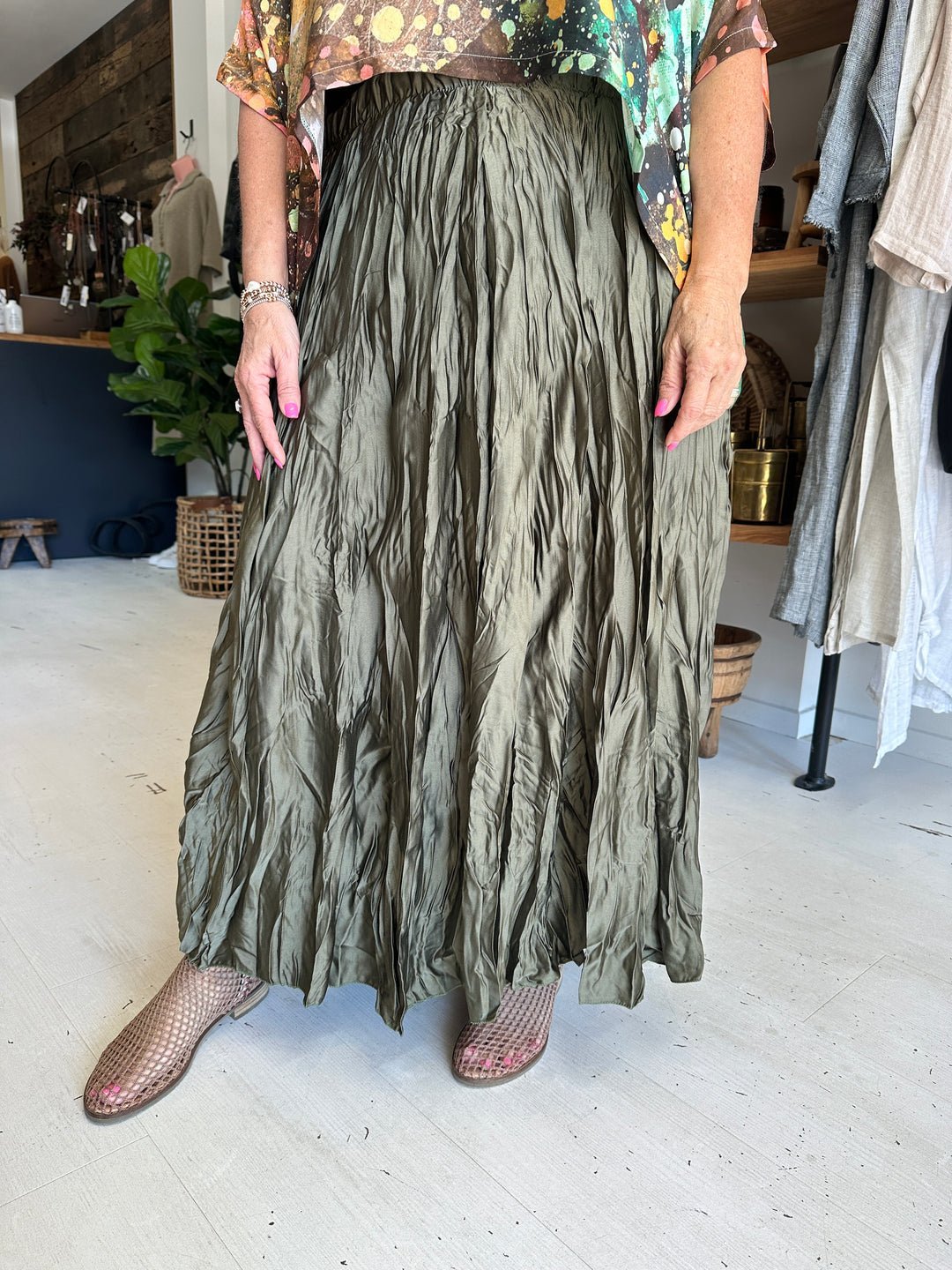 Jupe longue de style bohème est confectionnée dans un satin vert olive froissé métallisé pour un effet texturé unique.   