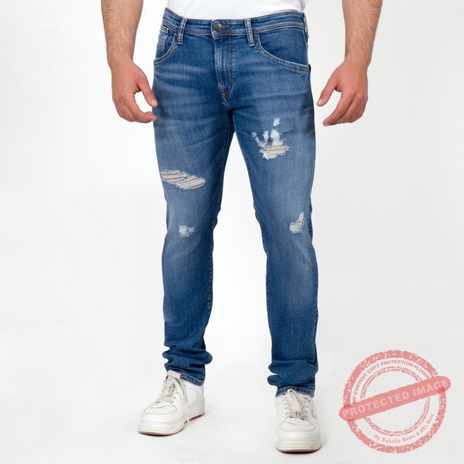 Un jean bleu déchiré pour homme slim fit , probablement de la marque Zara, avec des coupes droites et larges.