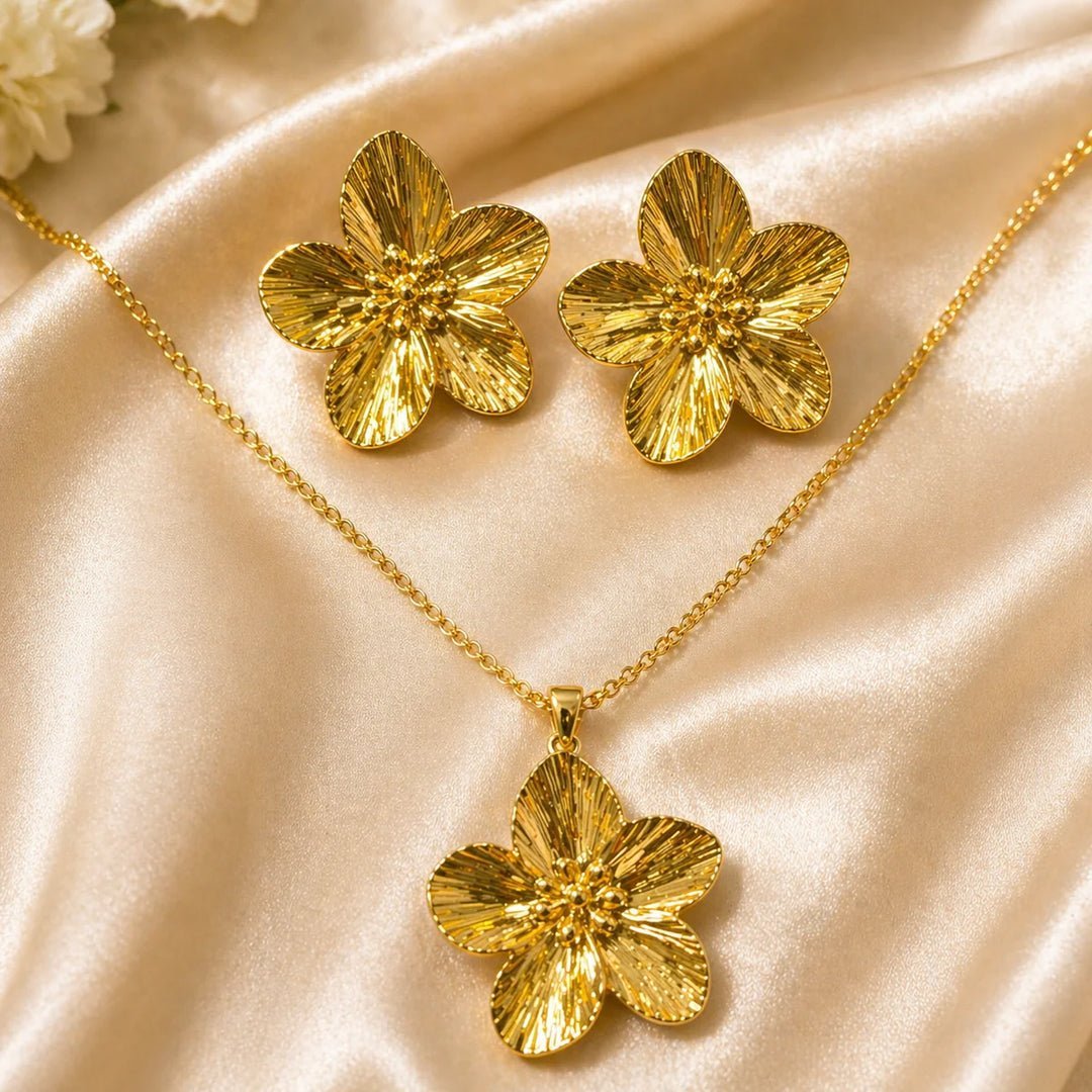 Ensemble de bijoux est composé d'un collier et de boucles d'oreilles en acier inoxydable doré, caractérisé par un motif de fleur texturé.