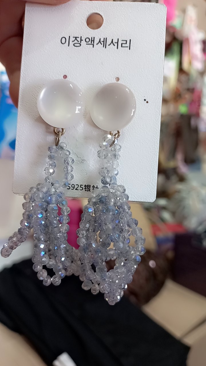 Boucles d'oreilles pendantes présentent des perles blanches translucides et des grappes de petites perles gris argenté.