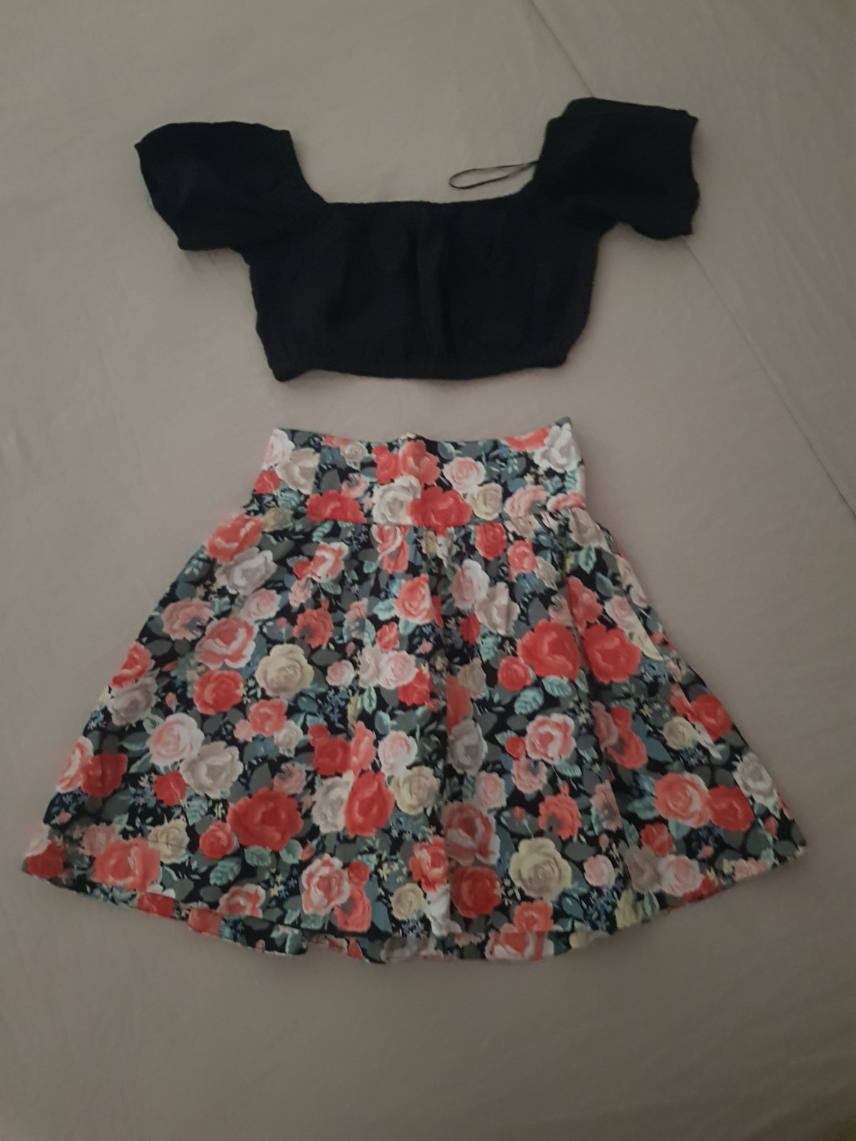 Ensemble se compose d'un haut court noir à manches courtes et d'une mini-jupe patineuse à imprimé de roses rouges et pastel