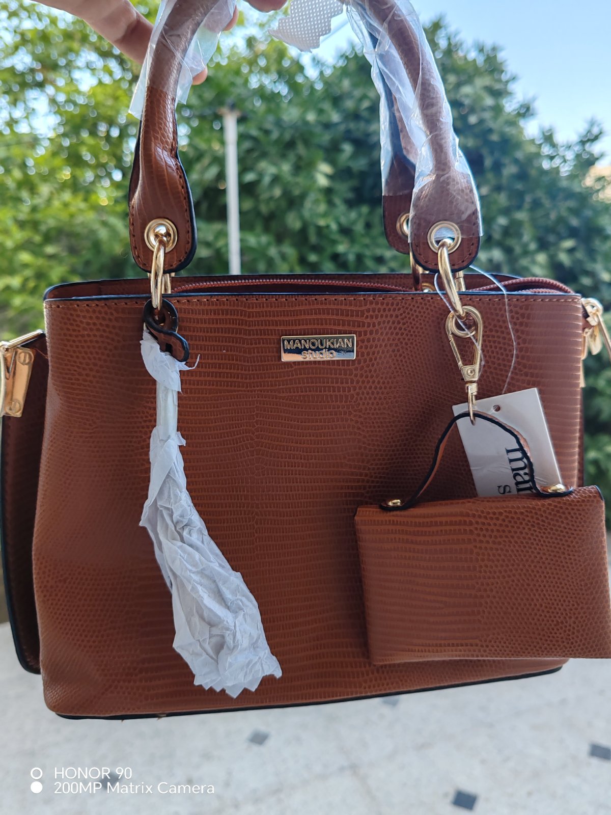 Sac à main en cuir synthétique marron texturé avec une petite pochette assortie de la marque Manoukian.