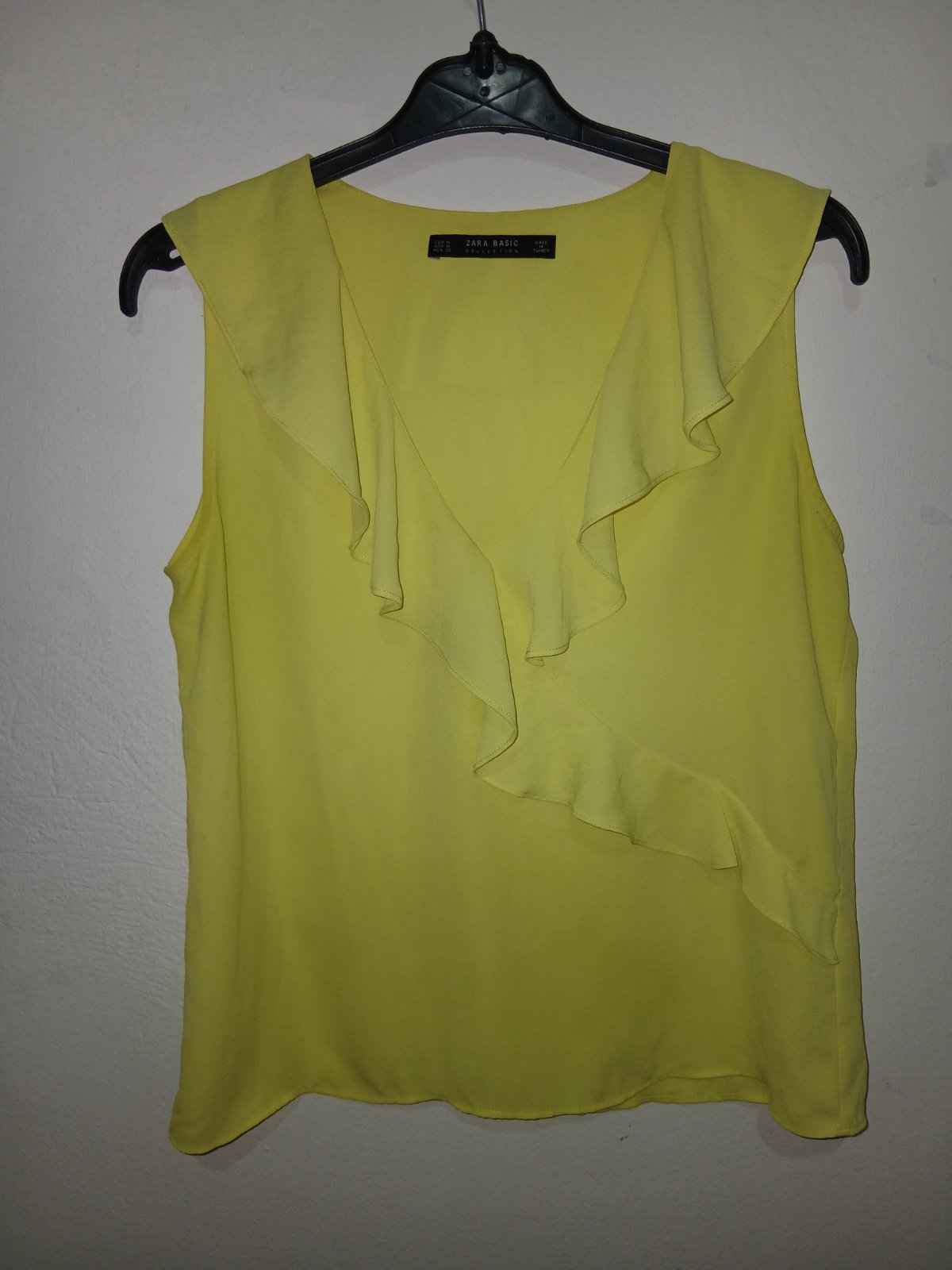 Cette chemise jaune Zara avec col en V volanté et sans manches est une pièce élégante de la collection Zara Basic
