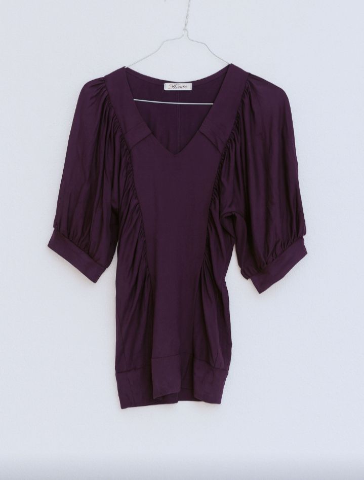 Haut féminin violet foncé, coupe élégante avec décolleté en V et manches mi-longues bouffantes.