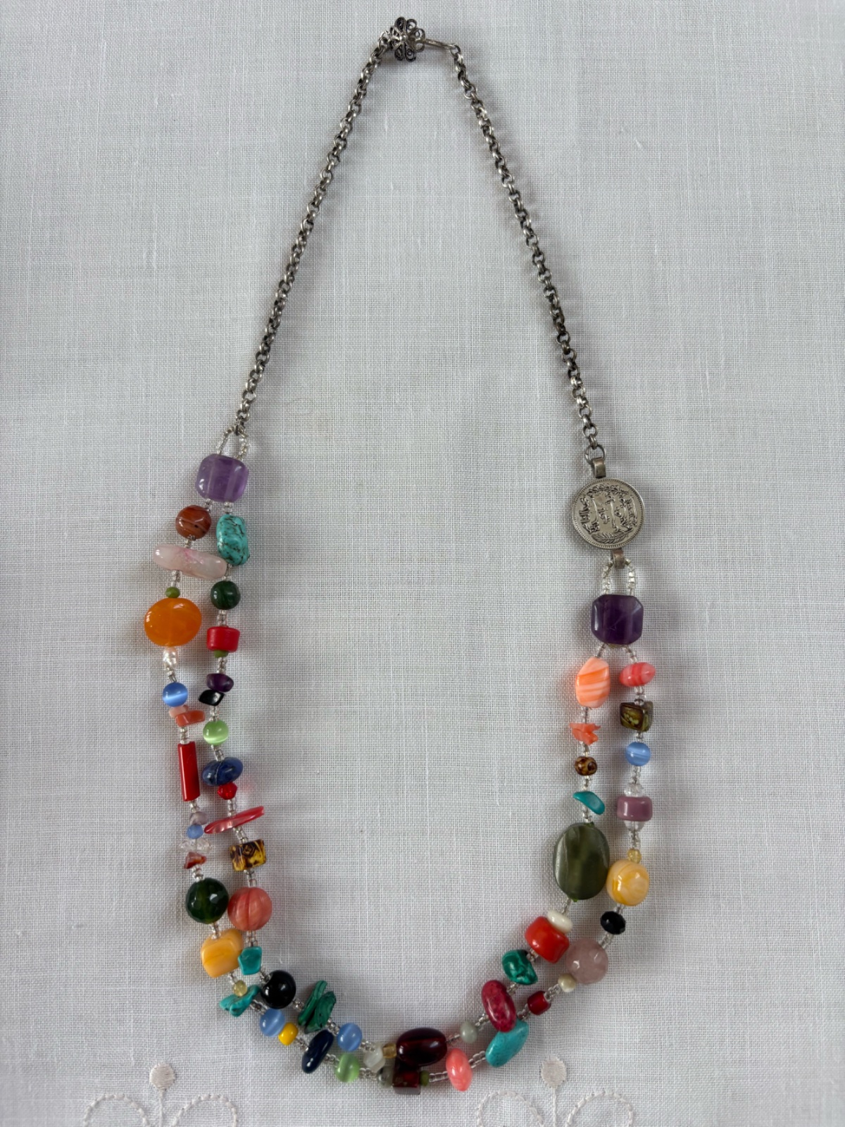 ✨Collier multicolore associant pierres fines et autres ainsi qu'une pièce de monnaie ancienne monté sur une chaîne en argent avec un fermoir original.✨