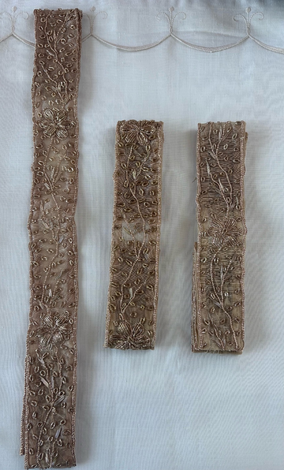 Rubans décoratifs en tulle transparent beige nude, entièrement brodés avec fils dorés. Motifs floraux avec petits détails scintillants. Parfait pour customisation de robe de soirée, caftan, ceinture ou accessoires 