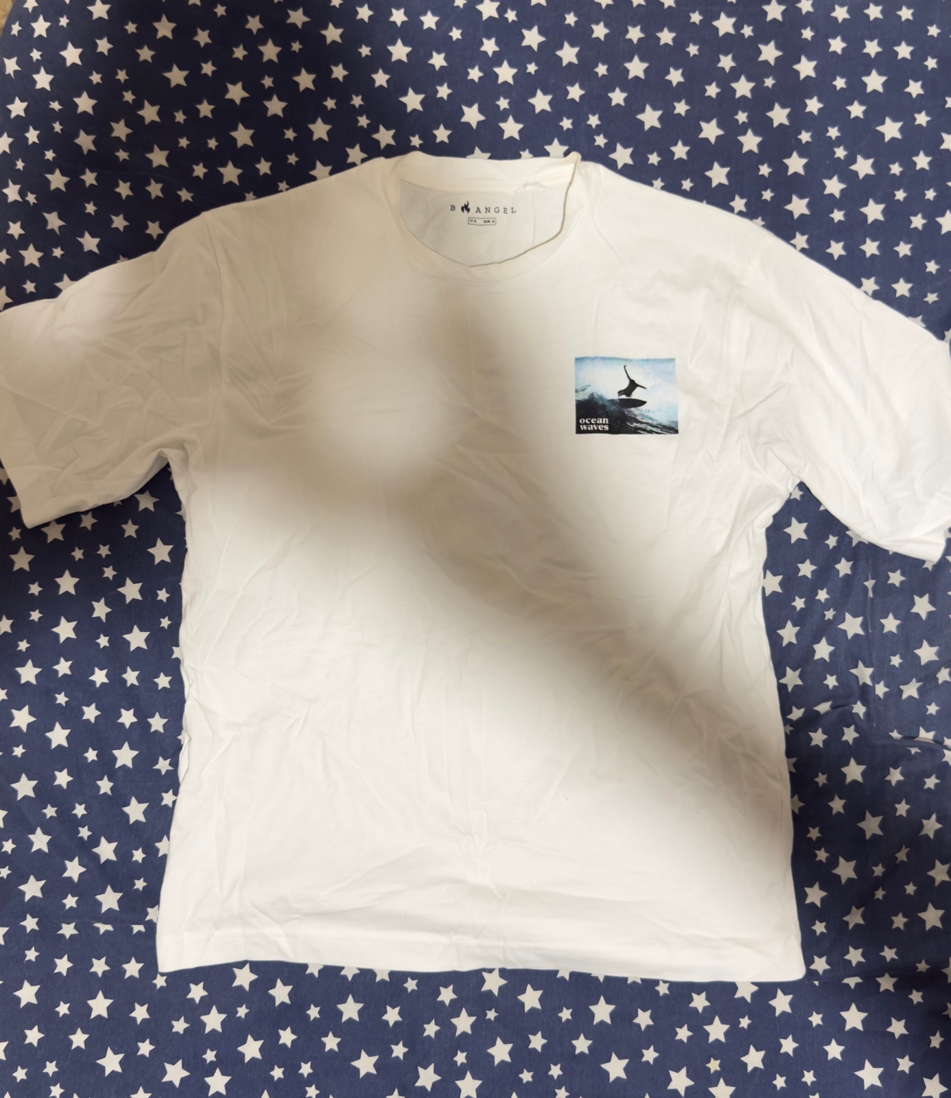 B.ANGEL white t-shirt features a small graphic Ocean waves