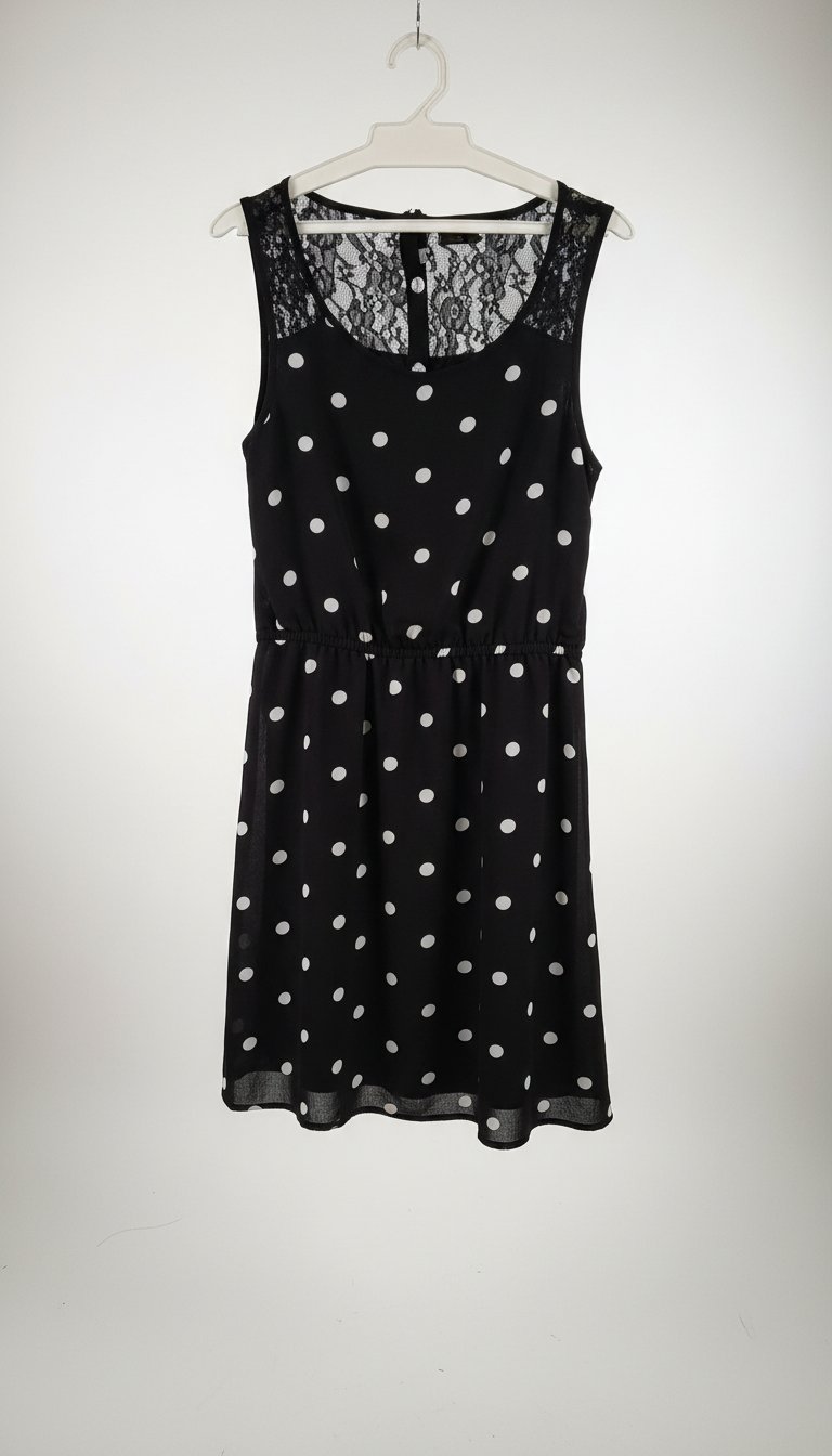 Une jolie robe noire avec des points blancs deriere ilaya une partie avec un peu de dentel