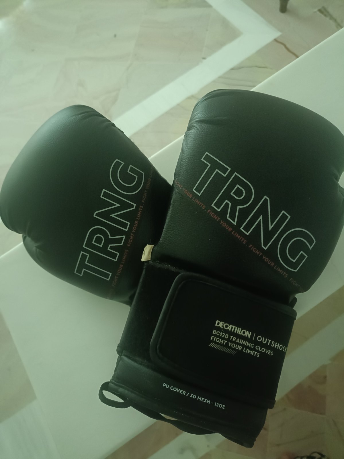Une paire de gants de boxe noirs Outshock BG120 de Decathlon en taille 12 oz.