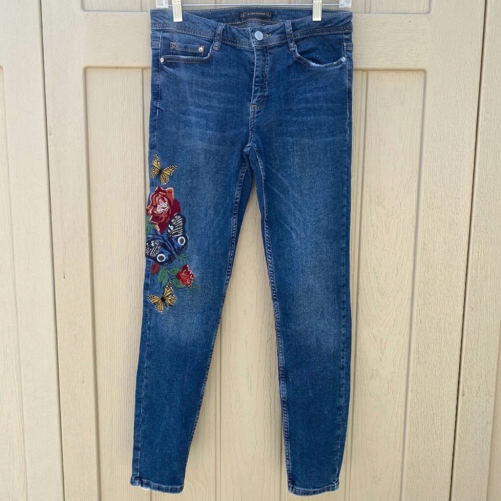 Un jean skinny pour femme de la marque Zara avec des broderies florales et de papillons sur la jambe.