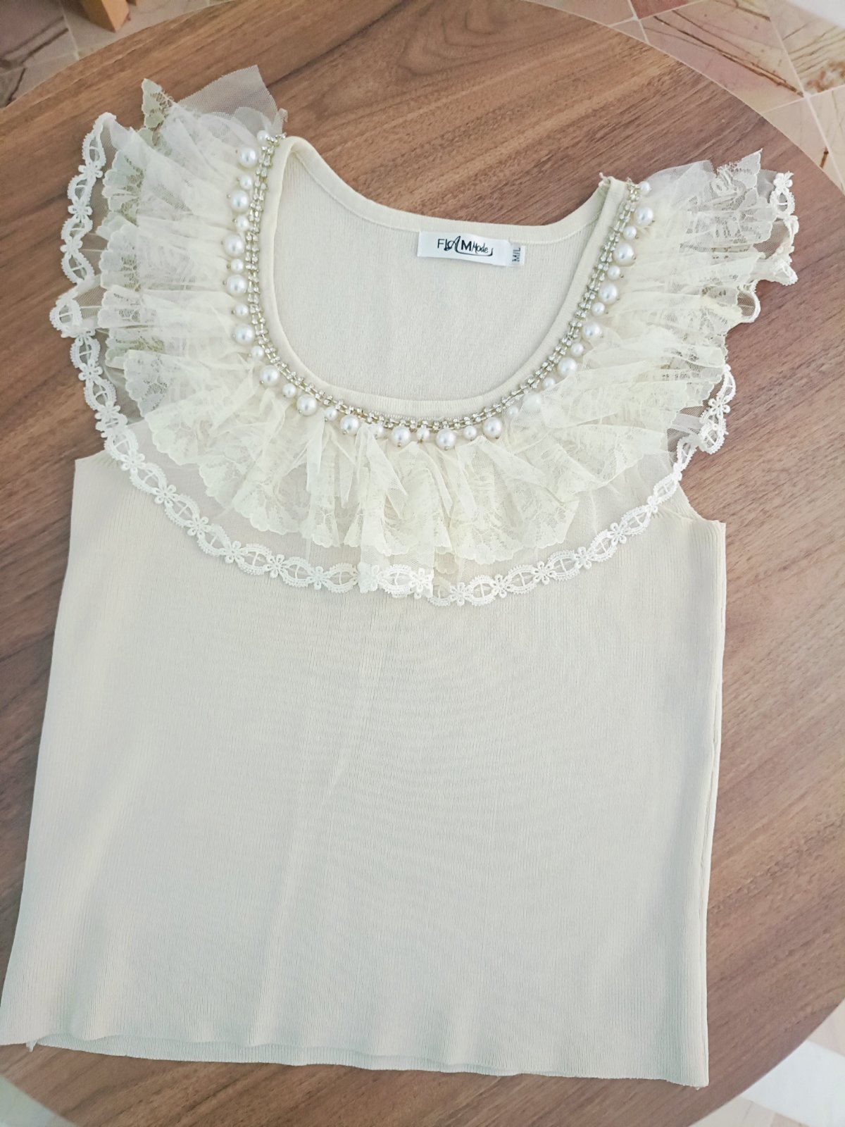 Sublimez vos tenues avec ce magnifique top beige clair, parfait pour toutes vos occasions.