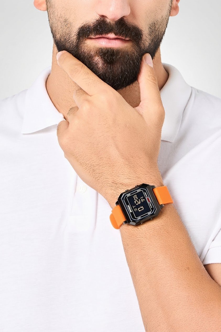 Une montre numérique carrée de la marque RBX avec un bracelet en silicone orange et un écran numérique.