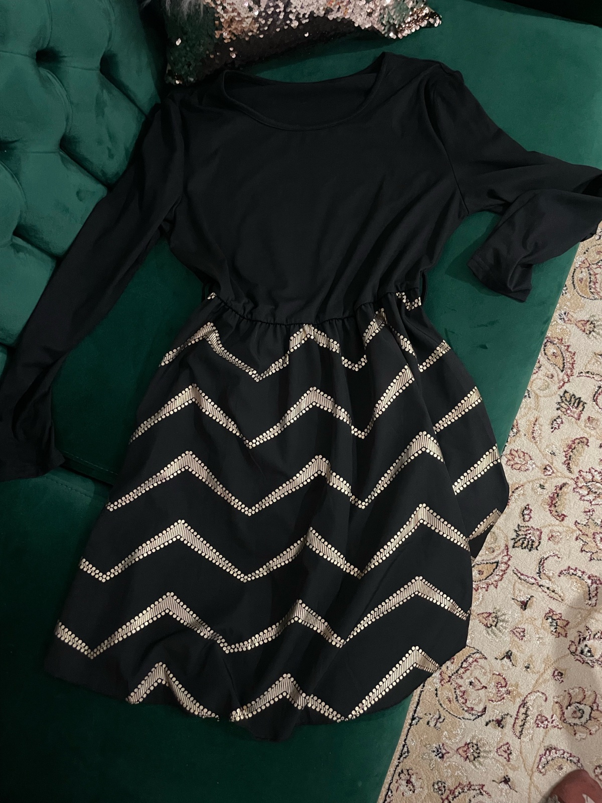 Robe patineuse bimatière noire féminine et moderne avec des manches longues et des imprimés dorés en forme de chevron sur la jupe