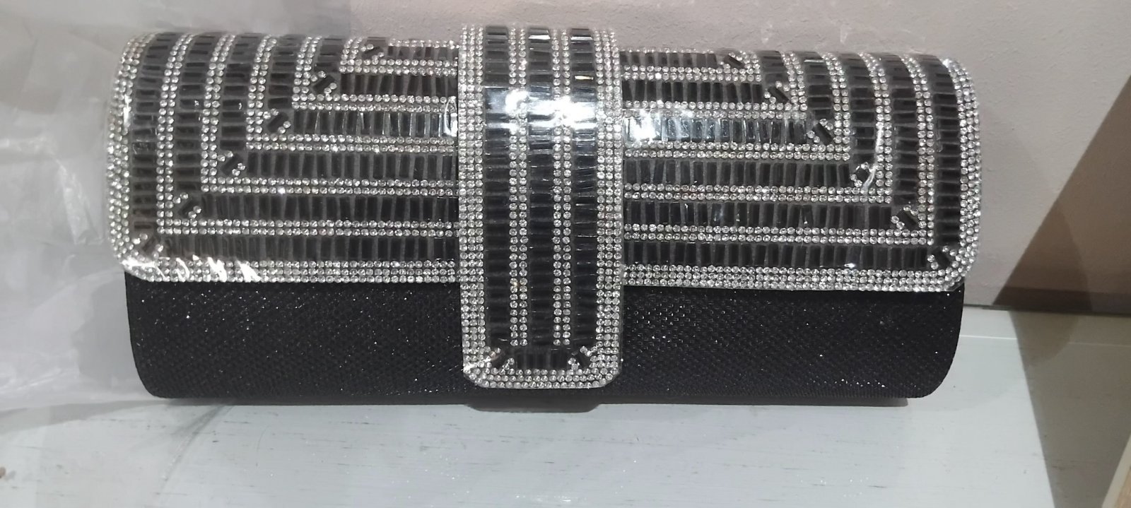 Une exquise pochette ornée de strass étincelants, dotée d'une bandoulière à chaîne amovible, parfaite pour les événements de soirée légers tels que les mariages