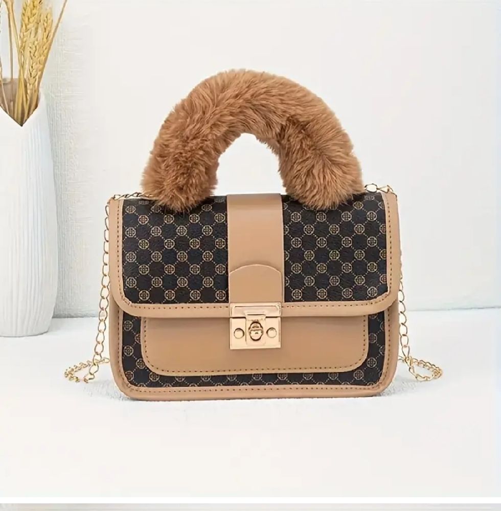 Un sac à main en peluche chic et vintage avec une fermeture à verrouillage sécurisé, doté d'une bandoulière avec une chaîne métallique. 