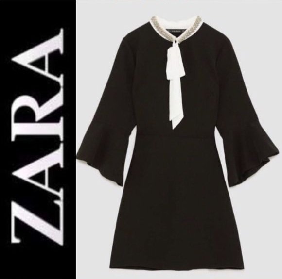 Black mini dress featuring a rhinestone-embellished collar and a white bow tie 