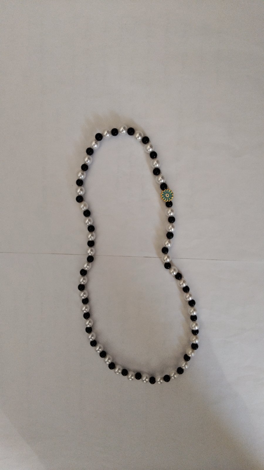 Collier noir et blanc avec fleur bleue 