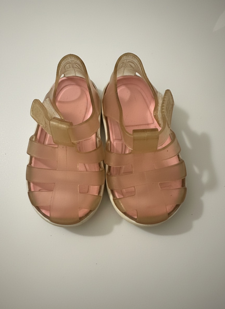 Ces sandales de plage pour bébé Decathlon Sun & Surf roses sont fabriquées en matière plastique translucide avec une bride réglable