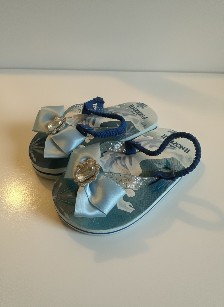 Ces tongs Disney Frozen II pour enfants sont ornées d'un nœud bleu satiné et d'un bijou en strass scintillant