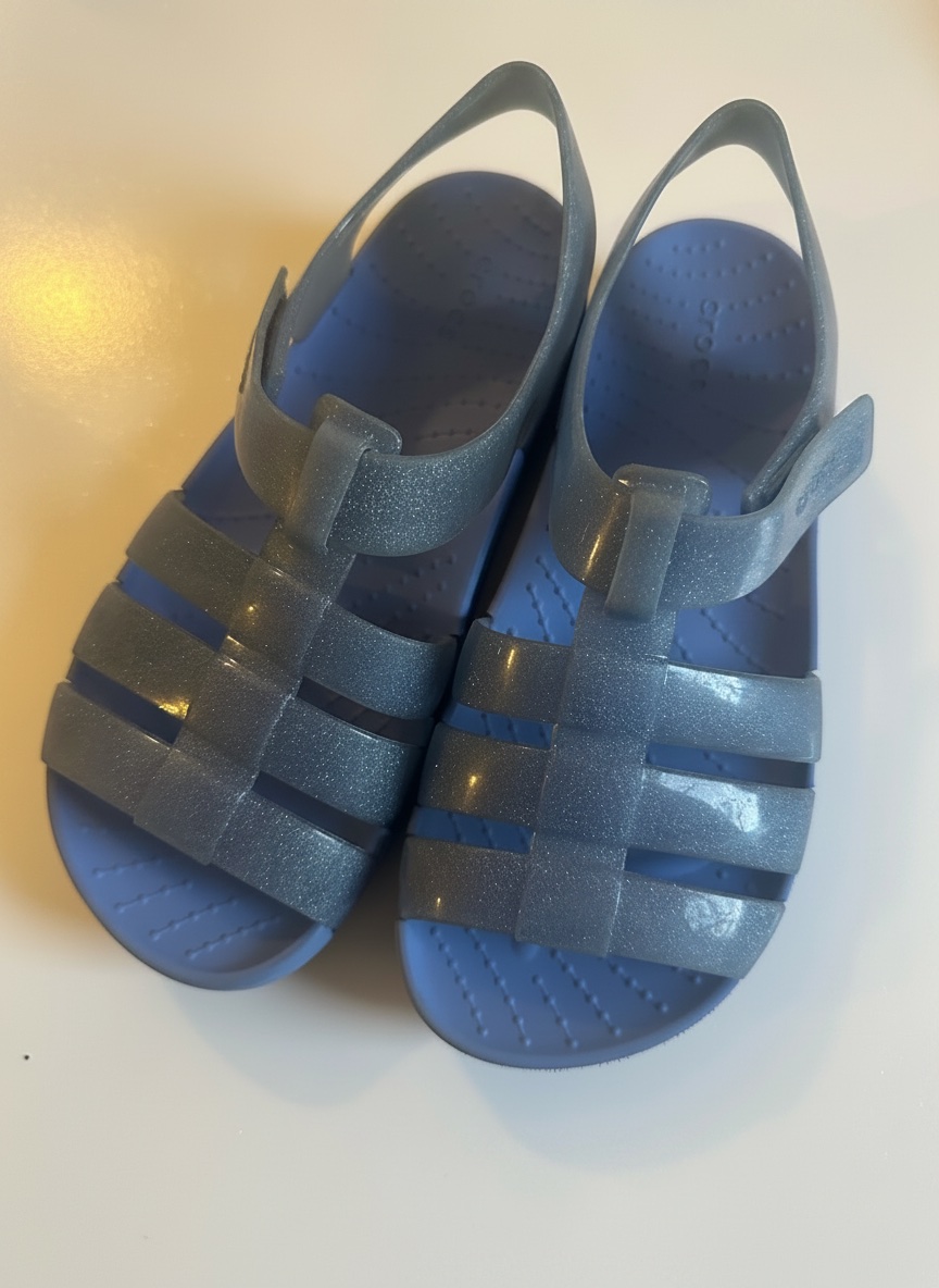 Ces sandales sont des Crocs Isabella Glitter pour enfants, dotées d'une finition scintillante bleue