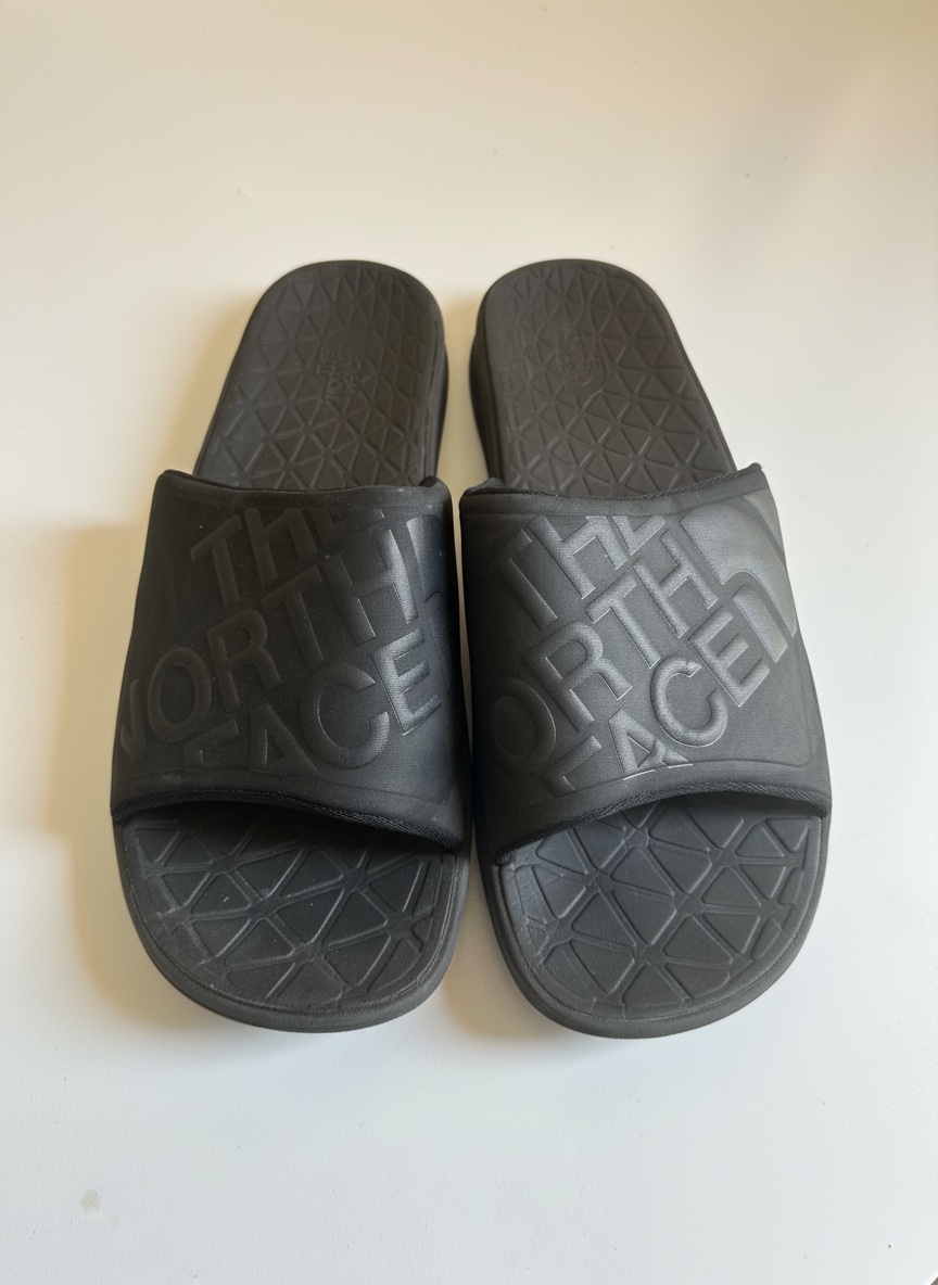 Ce sont des claquettes The North Face Base Camp Slide III noires avec un logo en relief