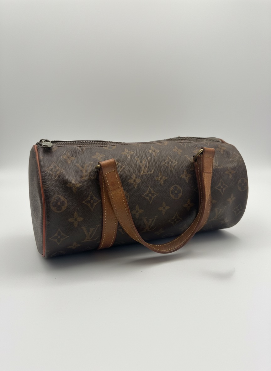 Ce sac à main Louis Vuitton Papillon est confectionné en toile monogrammée emblématique et présente des anses en cuir marron