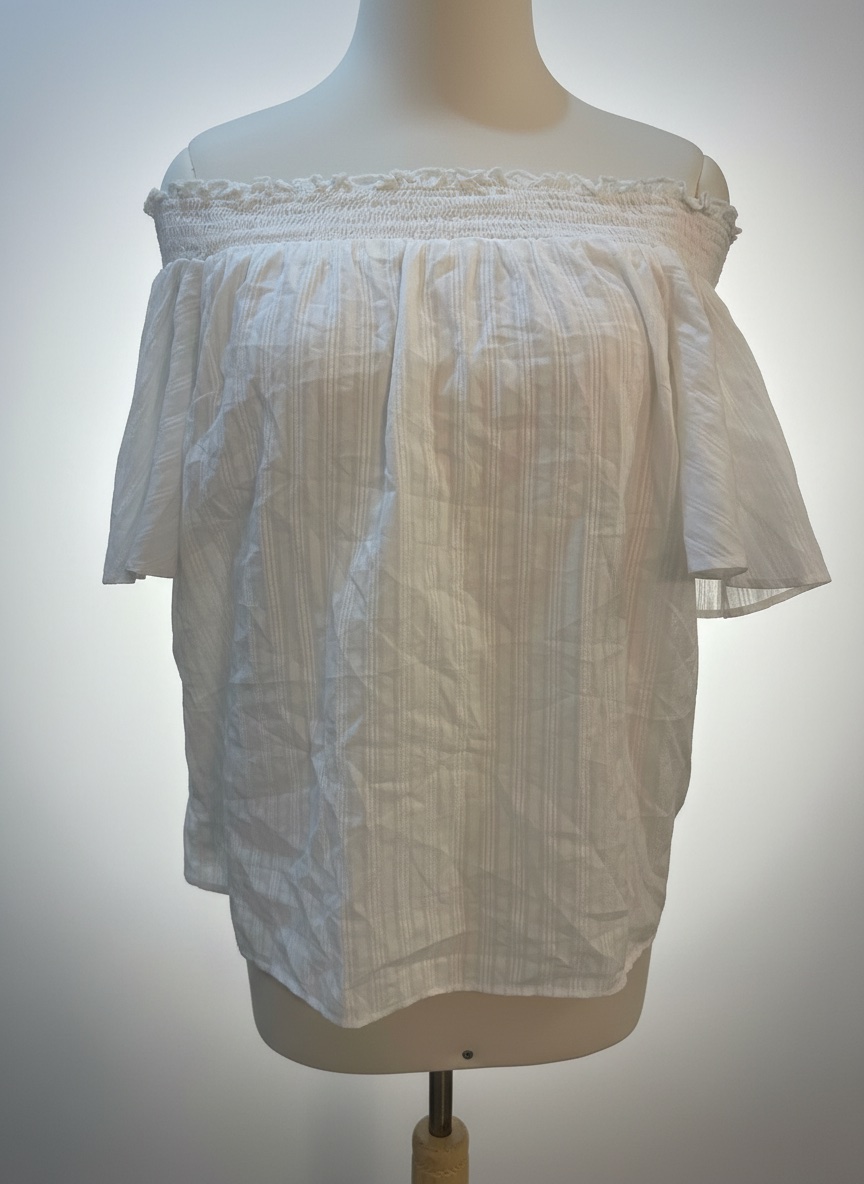 Cette blouse blanche à épaules dénudées avec des manches bouffantes