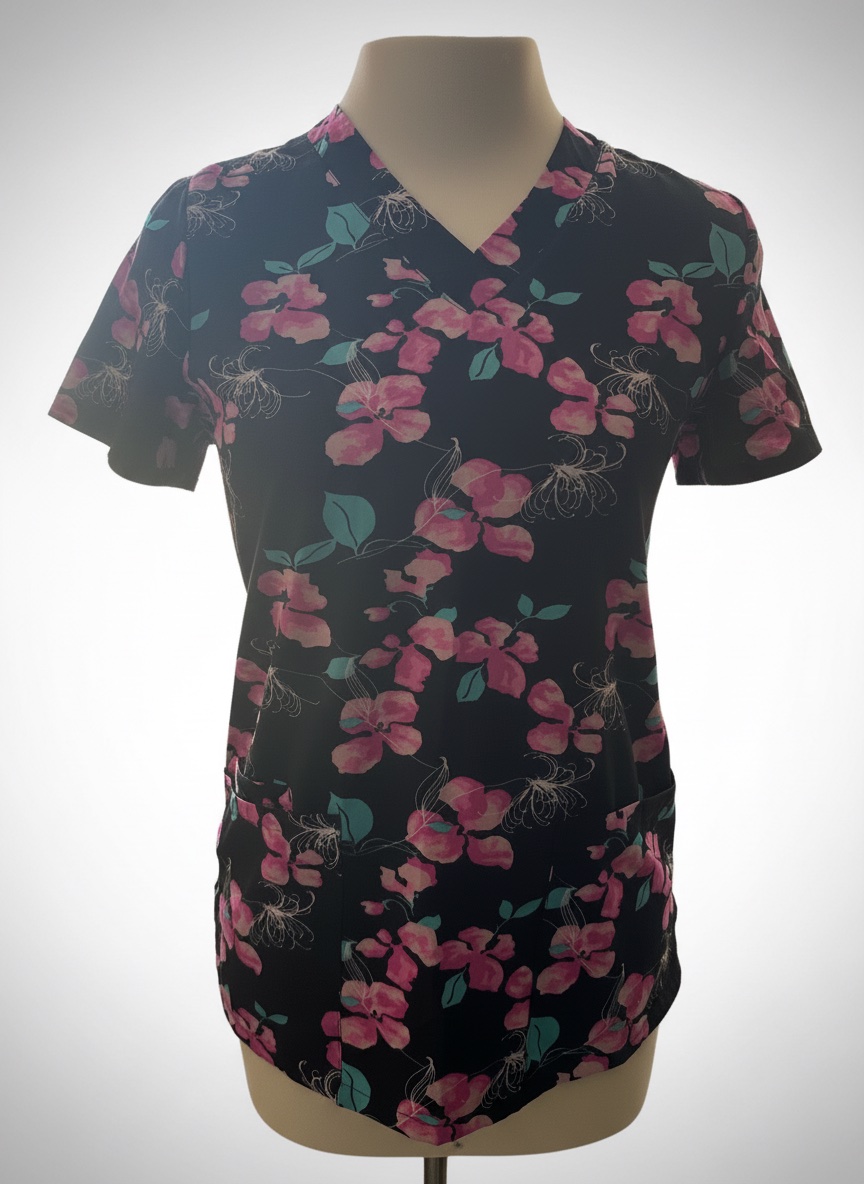 Ce haut est une blouse médicale à manches courtes de la marque Maevn avec un motif floral rose et bleu sur fond noir