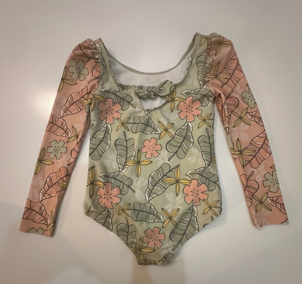 Ce maillot de bain une pièce Disney Moana pour tout-petits présente un motif floral tropical et des manches longues roses