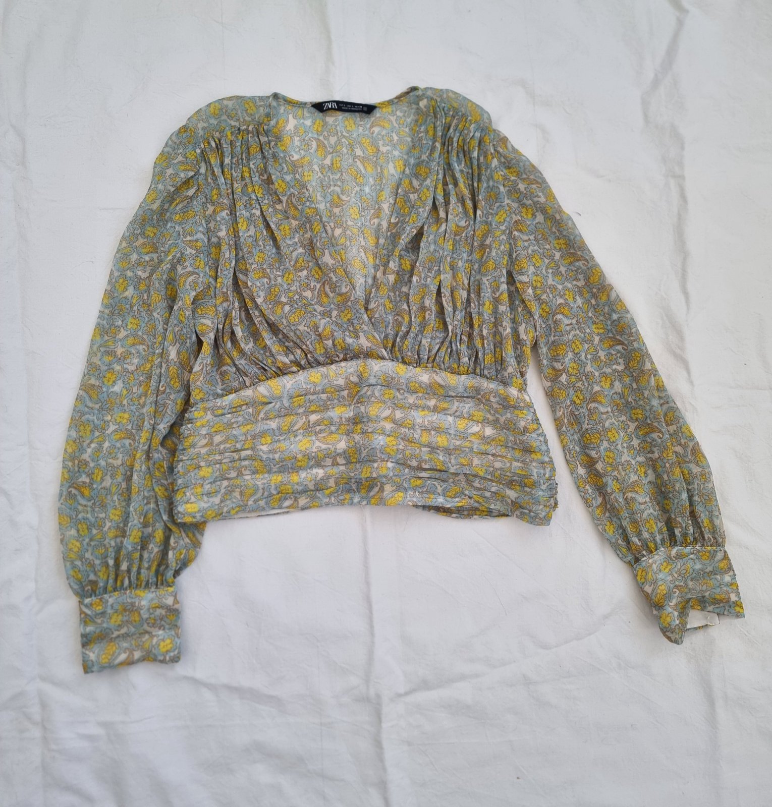 Un top fluide Zara au motif fleuri et coupe cache-cœur, idéal pour un look frais et élégant