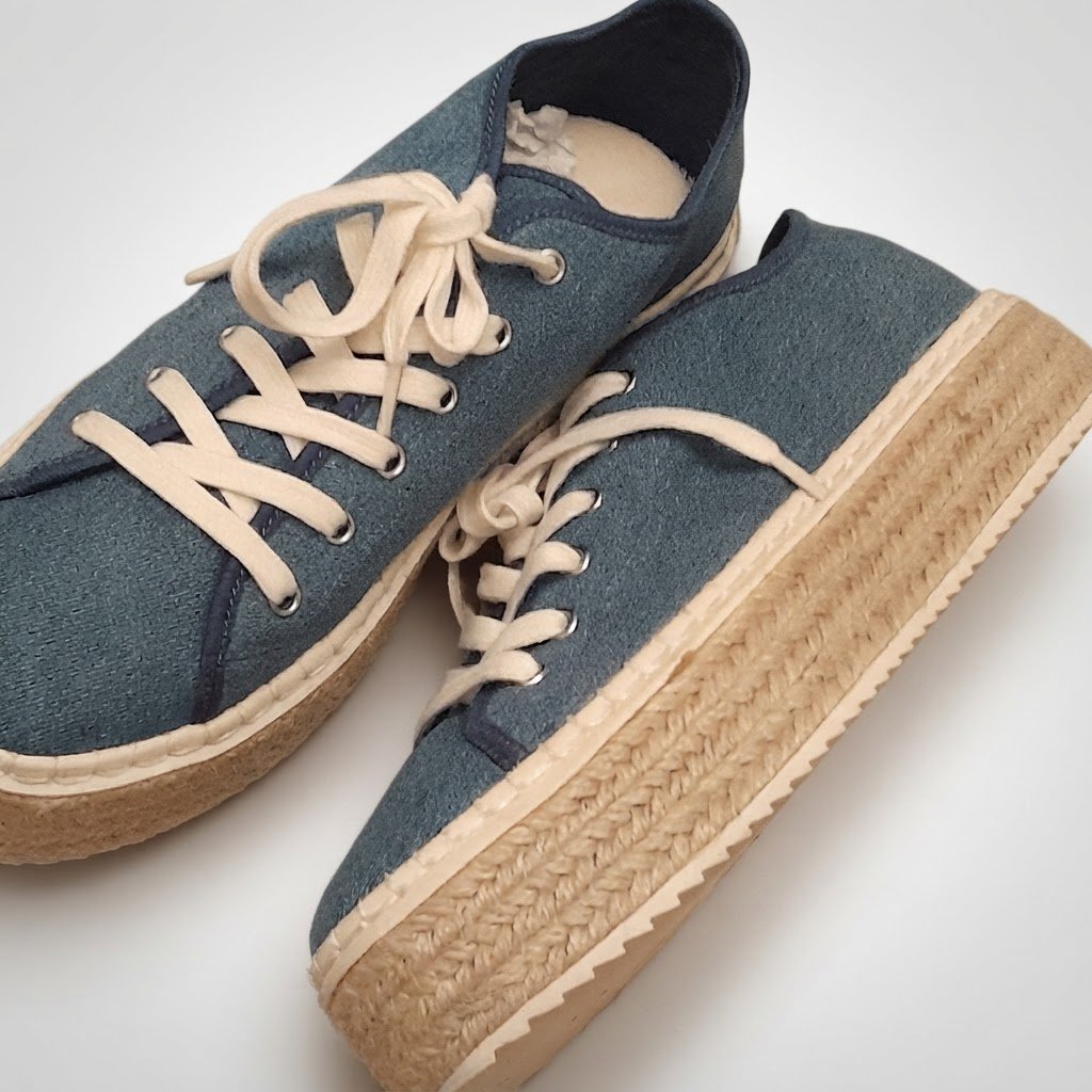 Baskets H&M bleu denim, avec lacets blancs, semelle beige/blanche et style casual. Elles sont en bon état général.