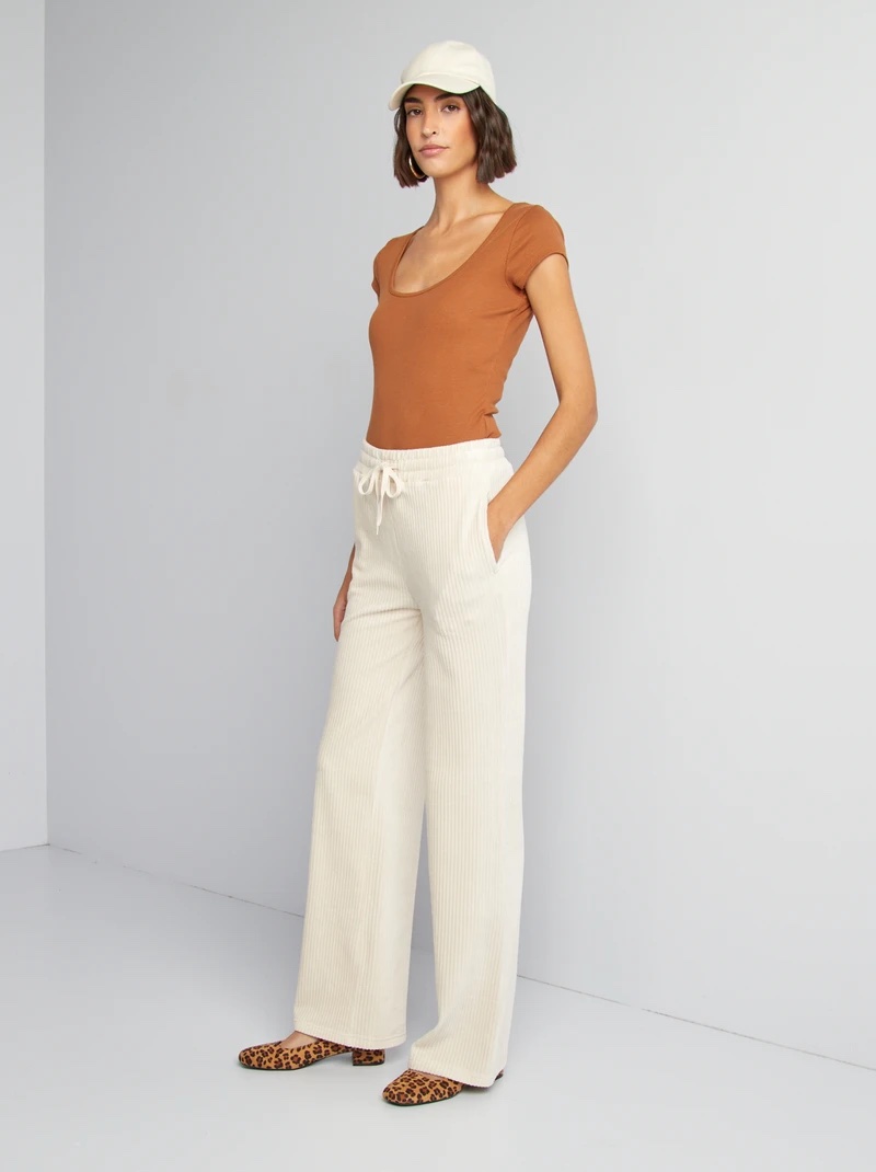 Pantalon de jogging large en velours côtelé ou en maille côtelée texturée de couleur blanc/écru, doté d'une taille élastique smockée et d'un cordon de serrage blanc à nouer sur le devant