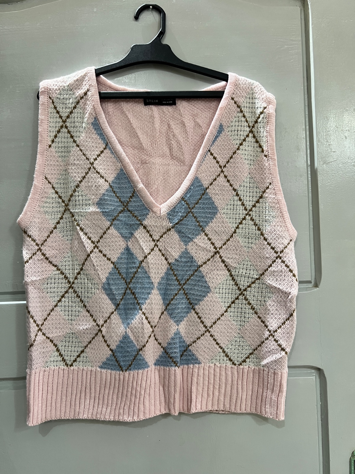 Gilet sans manches SHEIN en maille à motif losanges rose, bleu et blanc.