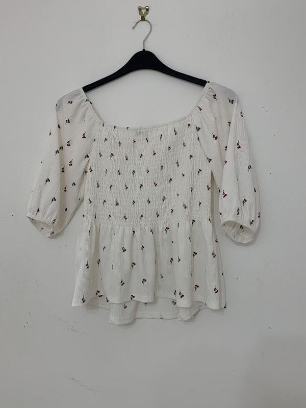 Pull blanc demi manche avec des fleurs rouges 