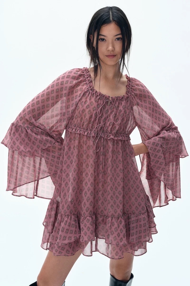 Robe est une robe courte H&M en mousseline vieux rose à motif et volants.