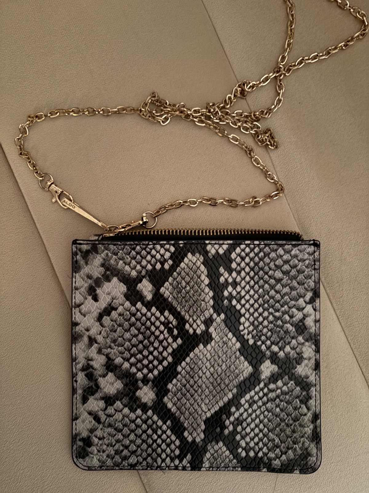 🔥🔥petite pochette zippée à motif  serpent gris et noir, dotée d'une longue bandoulière en chaîne dorée signée de la marque ALDO.🔥🔥