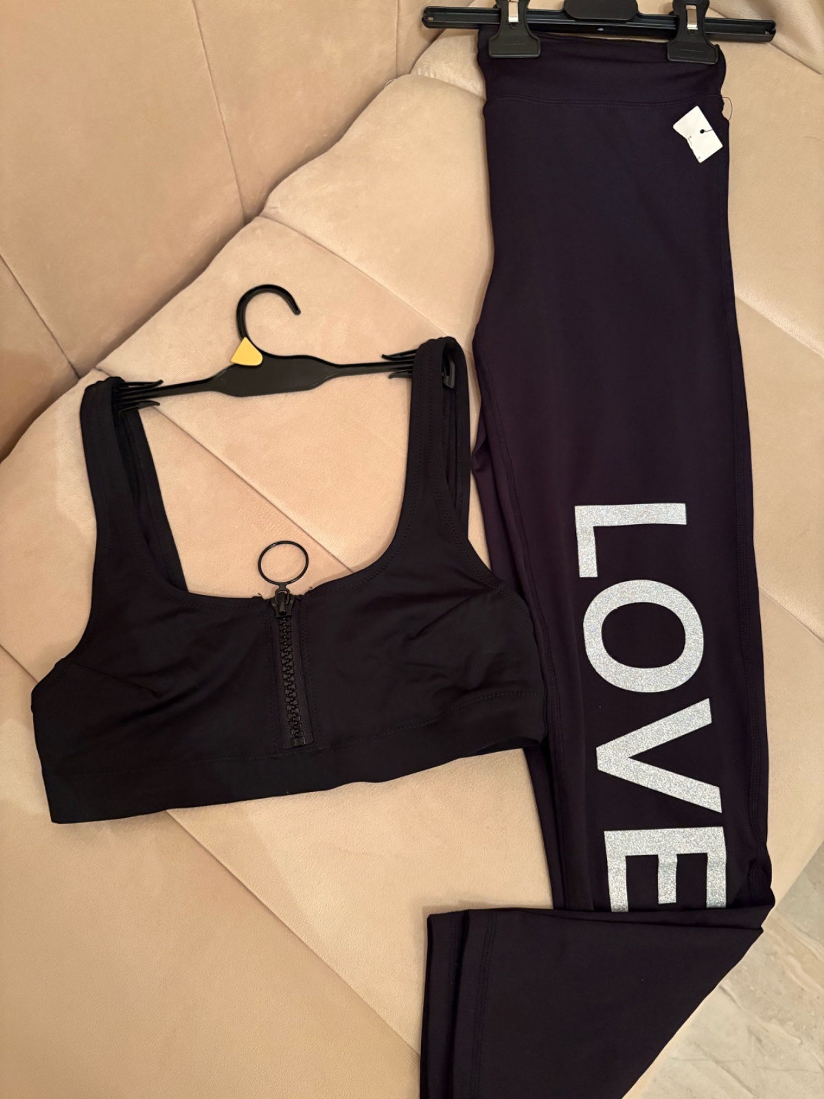 Ensemble de sport noir avec une brassière à fermeture éclair et un legging portant l'inscription « LOVE »